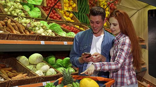 一对夫妇讨论超市智能手机购物清单视频的预览图