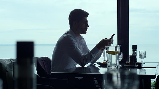 在豪华餐厅午餐时忙碌的商务人士在智能手机上阅读信息视频的预览图