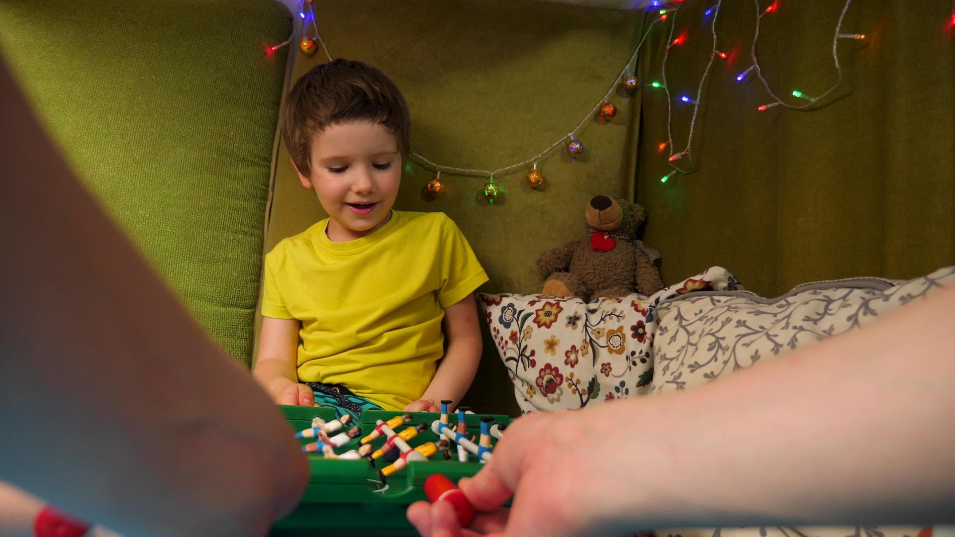 和孩子们一起玩桌面游戏男孩在一个有枕头的小游戏室里视频的预览图