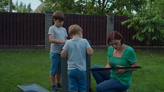 两兄弟明媚的日子里两兄弟帮助年轻的单身母亲在后院上课视频的预览图