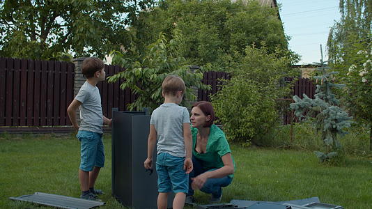 两兄弟明媚的日子里两兄弟帮助年轻的单身母亲在后院上课视频的预览图