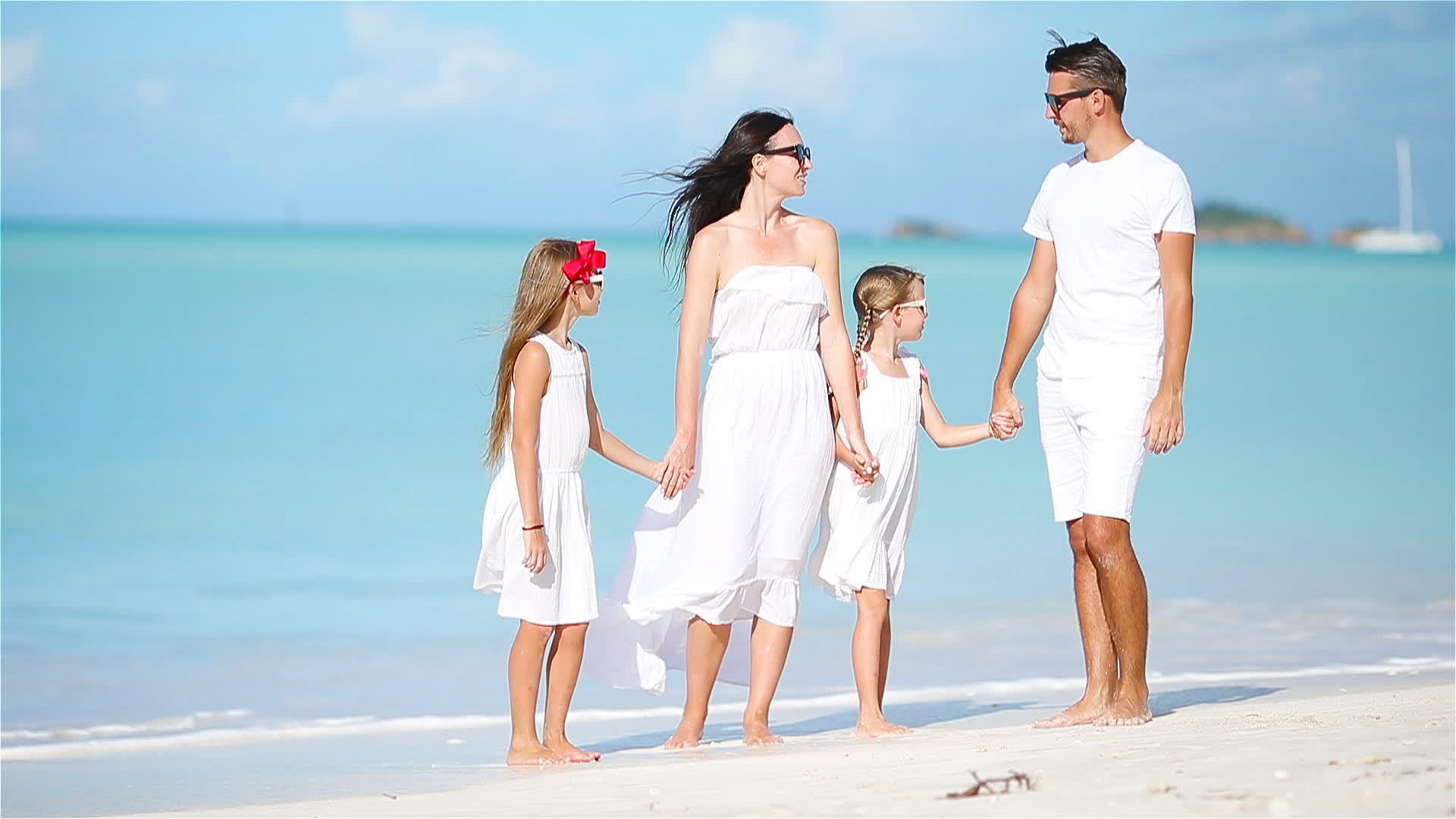 年轻美丽的家庭在白色的沙滩上视频的预览图