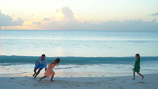 享受海滩度假的父亲和孩子的家人一起玩慢动作视频的预览图