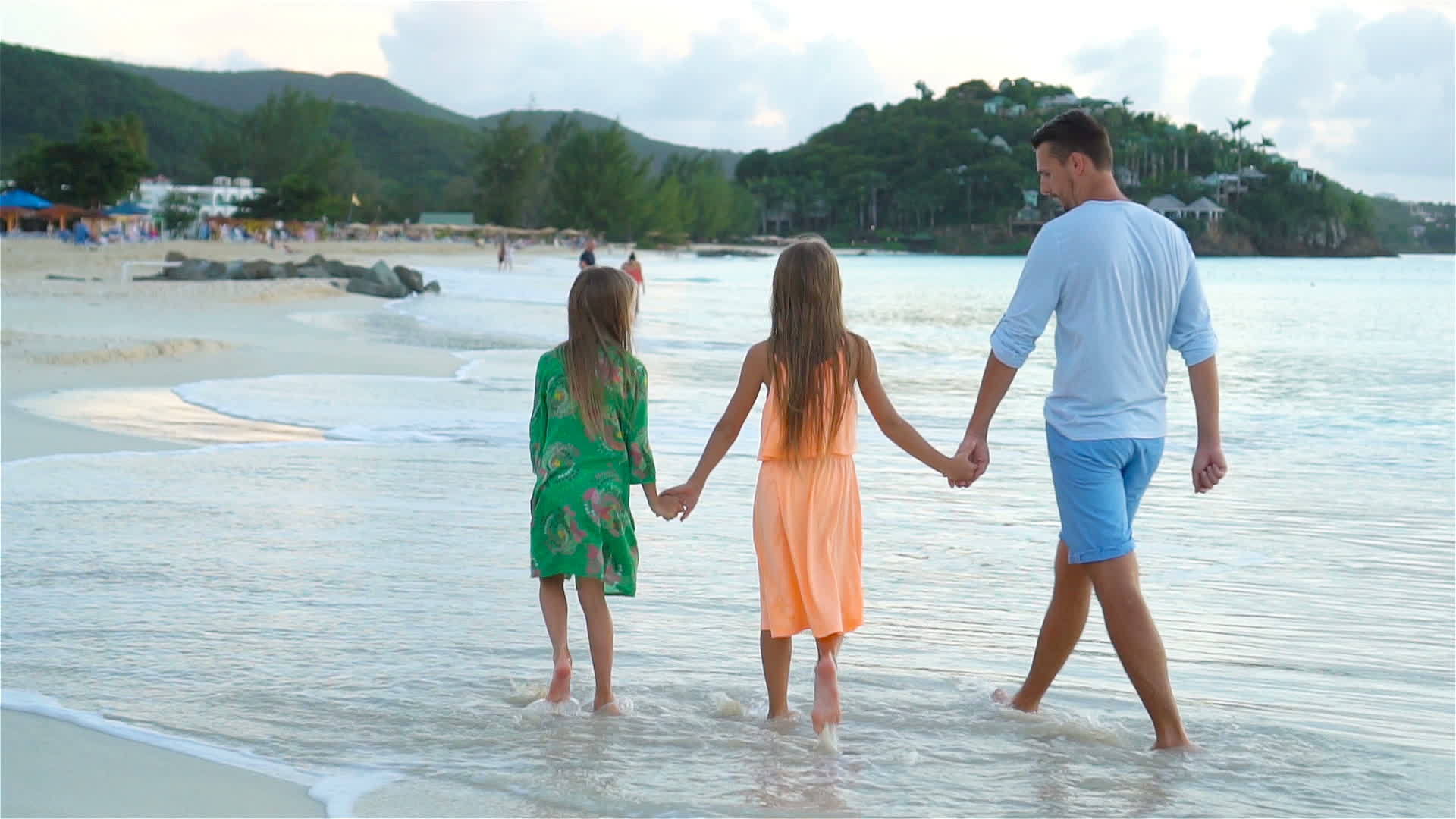 享受夏季热带海滩度假的家庭在海滩上慢慢散步视频的预览图