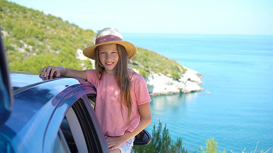 小女孩开车去度假汽车背景美景等等视频的预览图