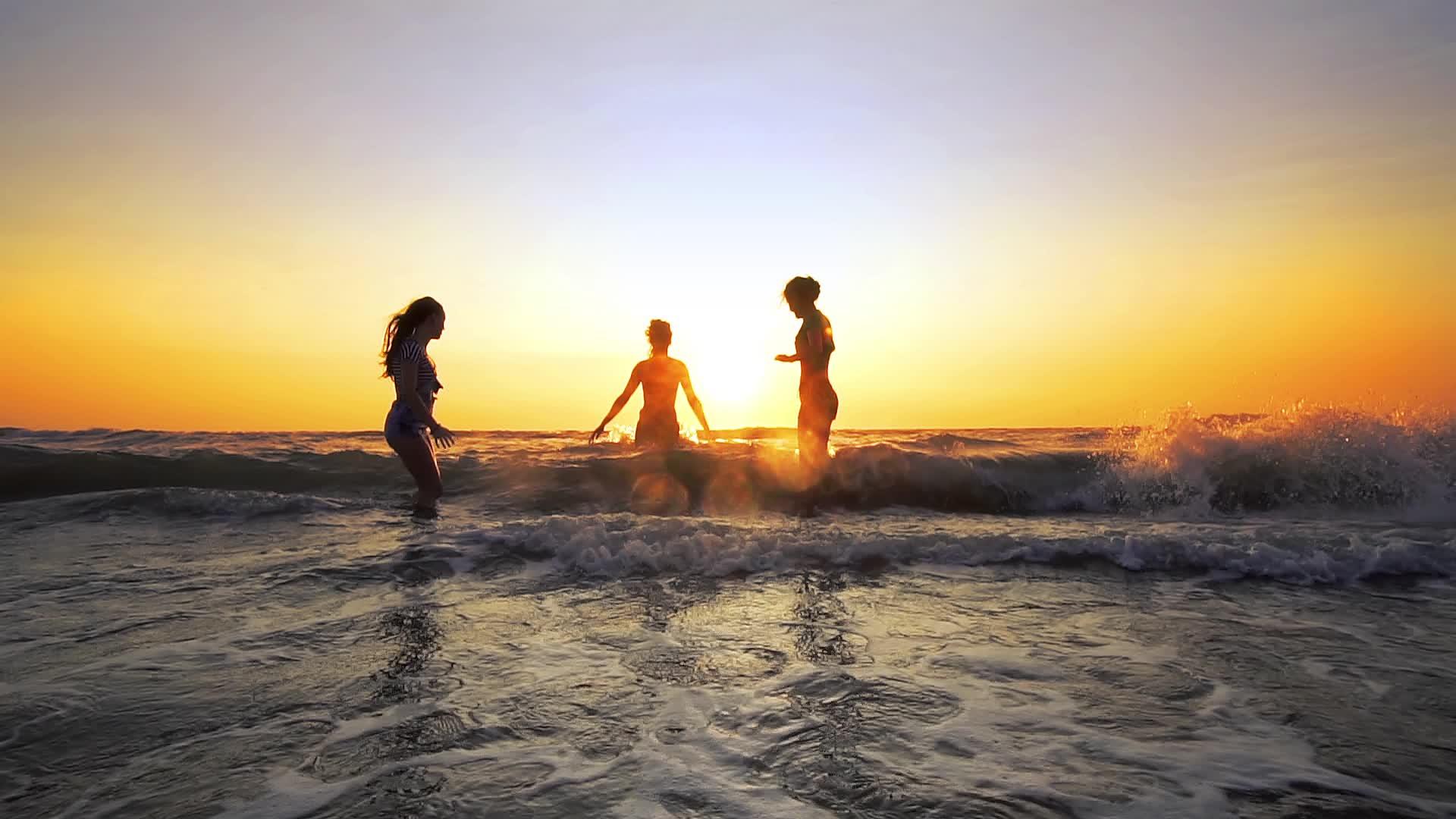 年轻女性在日落时跳舞在热带海滩在日落时跳舞视频的预览图