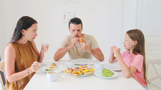 快乐的家庭在厨房一起吃早餐视频的预览图