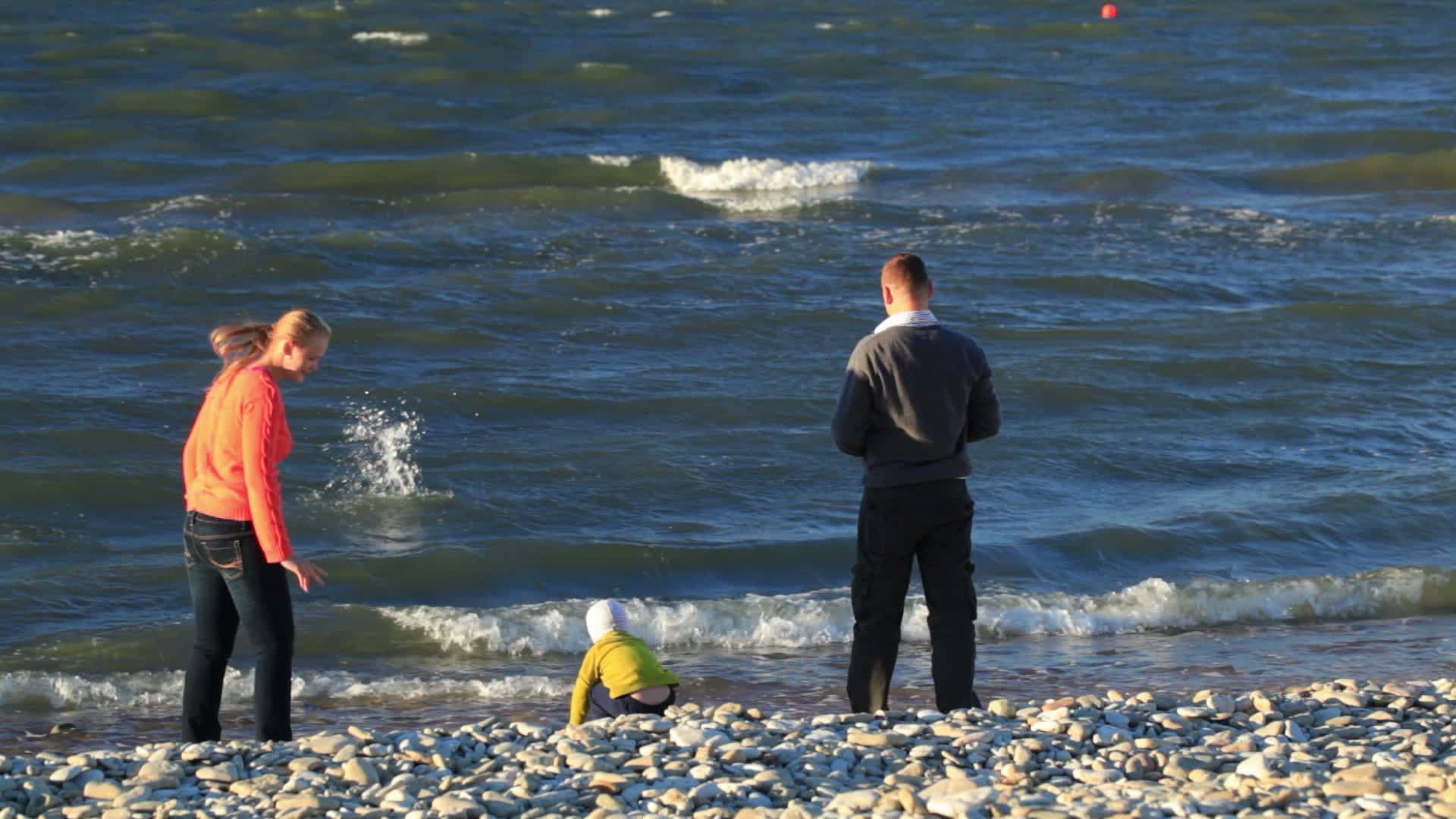 石头海滩上有三个家庭视频的预览图