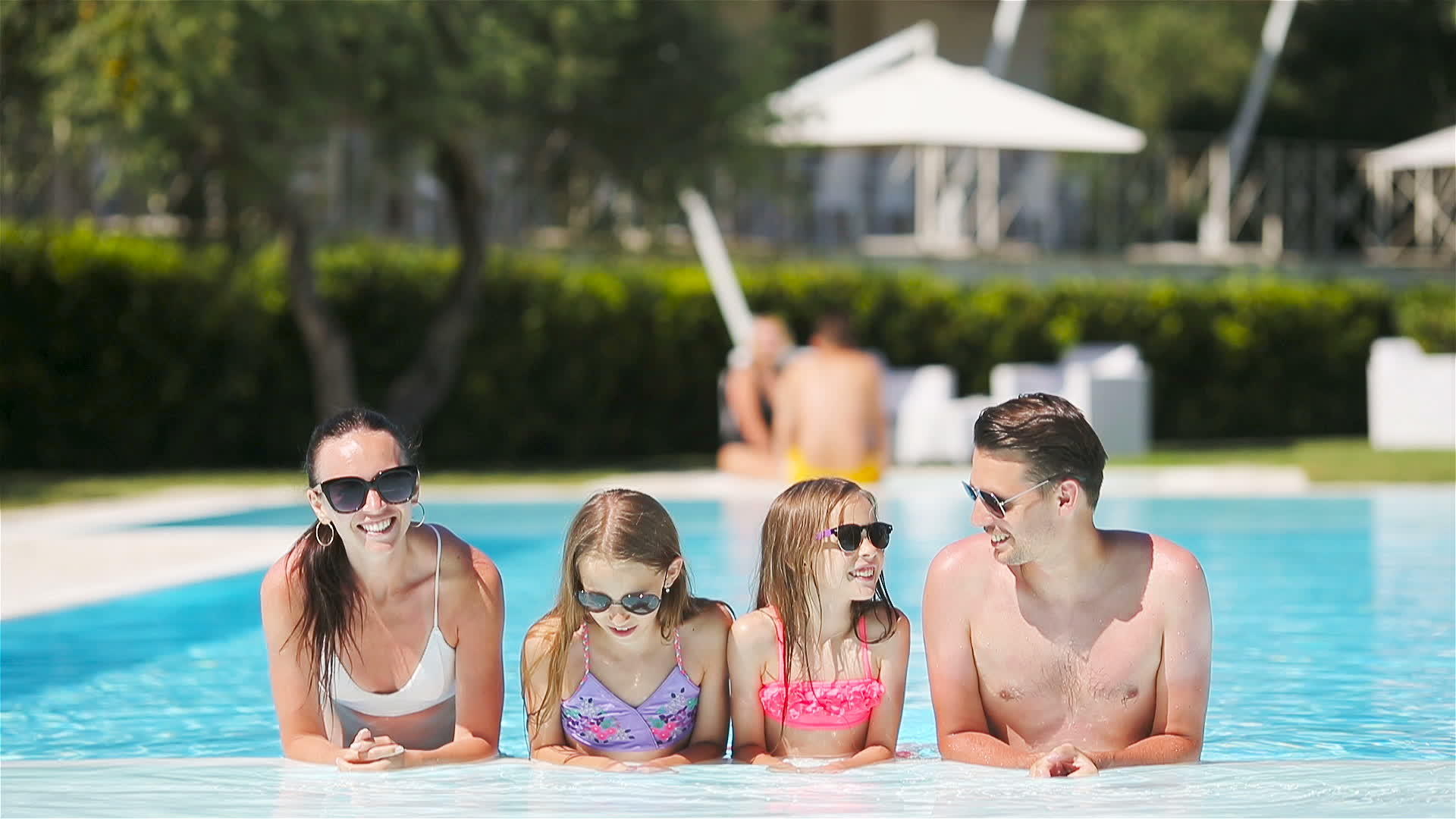 四个幸福的家庭在户外游泳池里视频的预览图