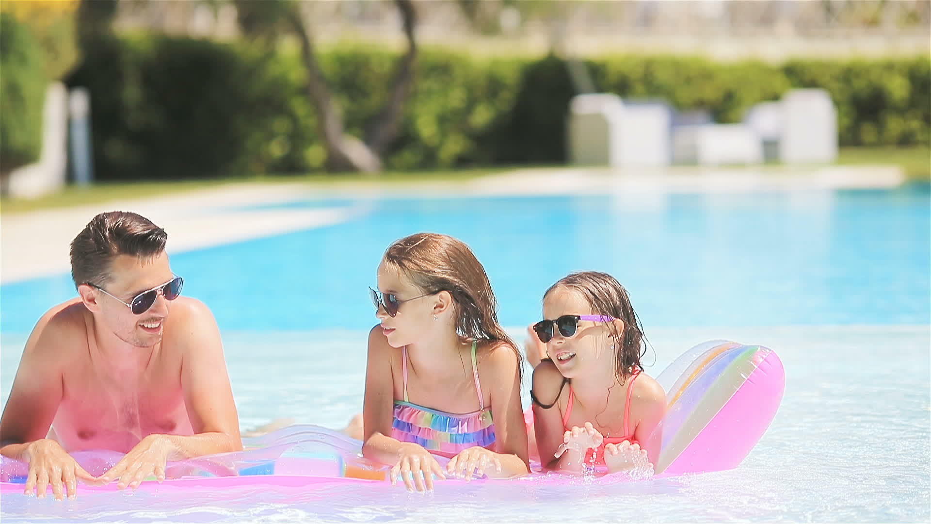 室外游泳池里有三个幸福的家庭视频的预览图