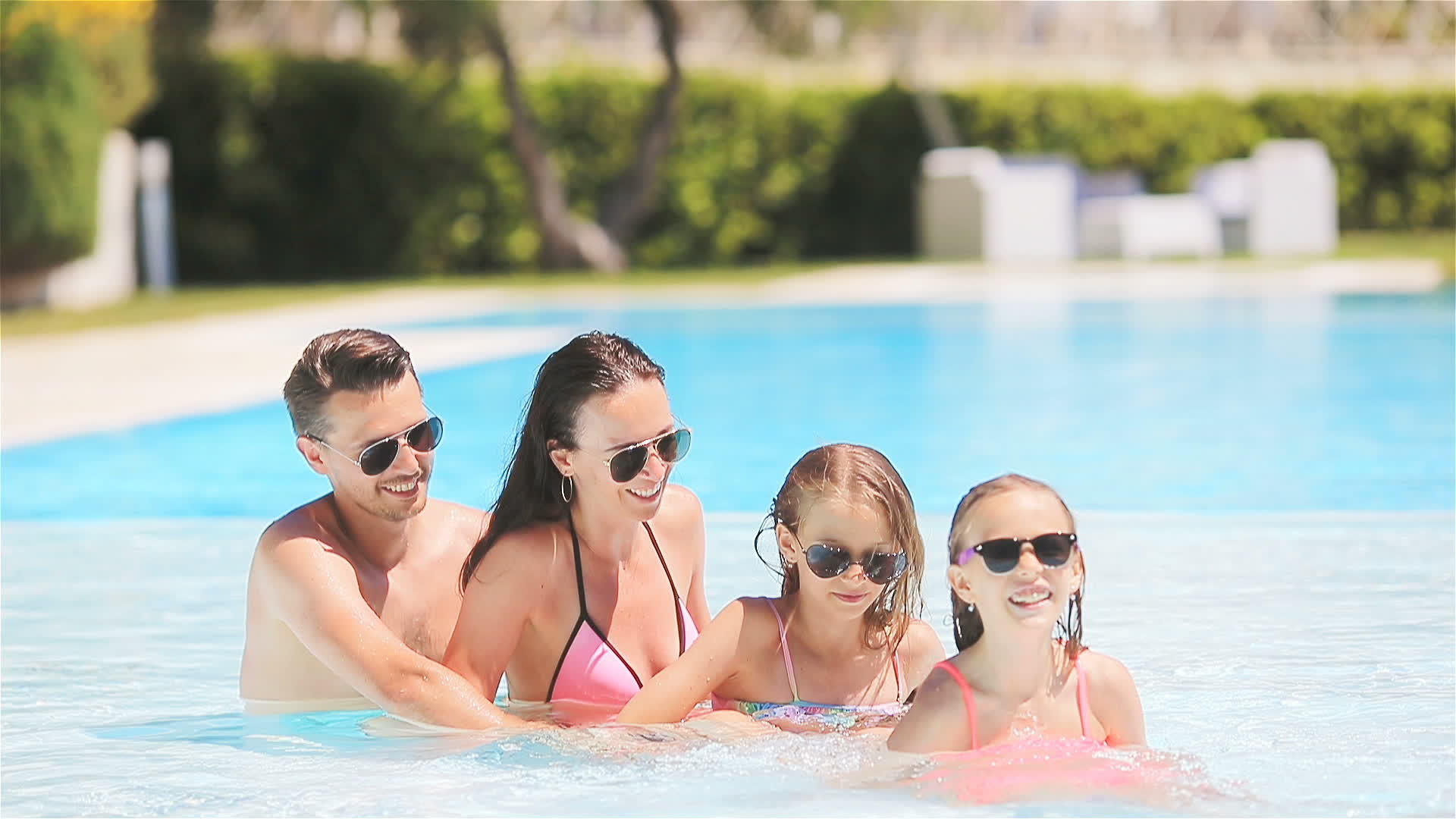 四个幸福的家庭在户外游泳池里视频的预览图