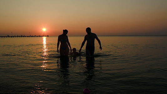 日落时三个人从海里出来视频的预览图