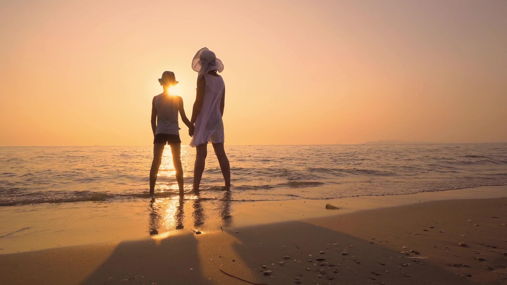 幸福的家庭母亲和儿子在日落的海滩上玩游戏拥抱和交流情感视频的预览图