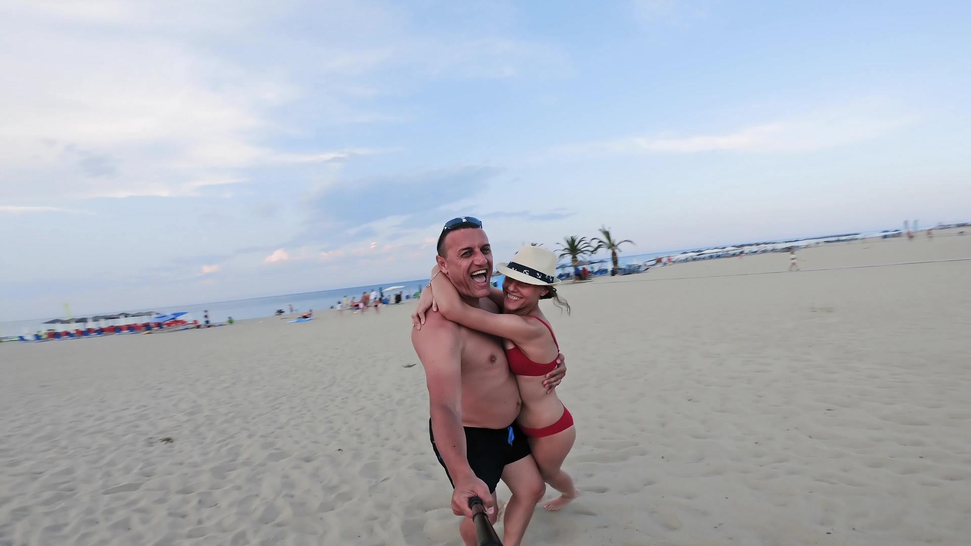 快乐的父亲和女儿在沙滩上拥抱和微笑视频的预览图