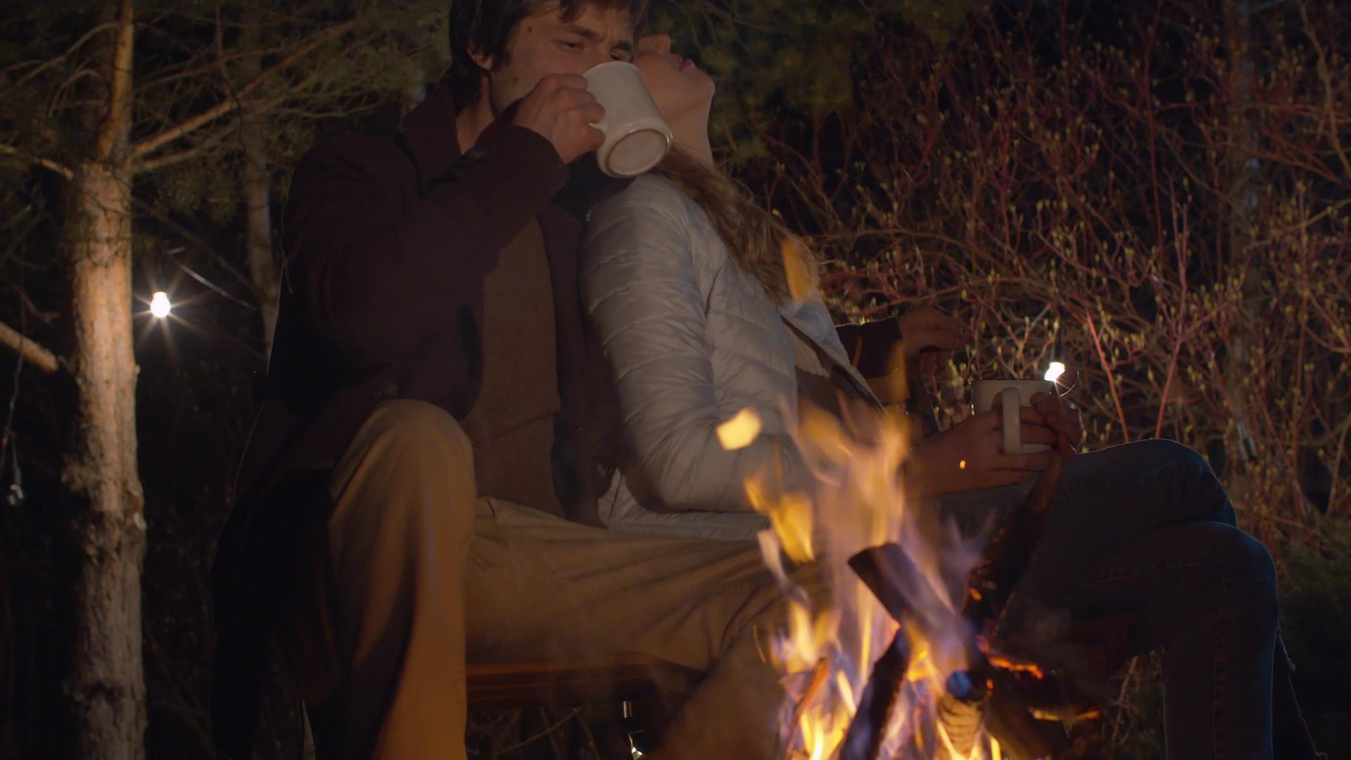 晚上在营火附近拥抱一对年轻夫妇视频的预览图