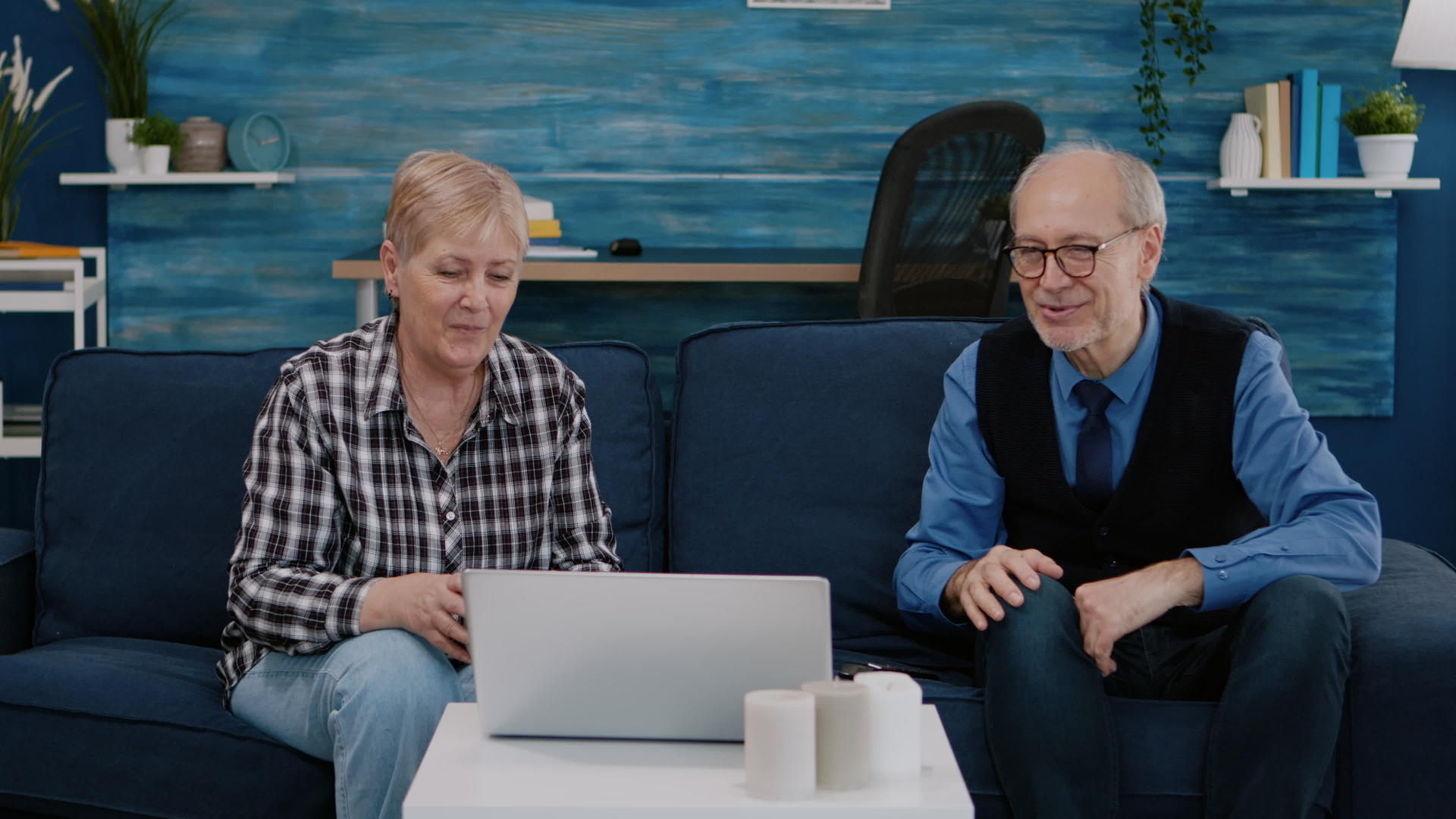老夫妇微笑着看着笔记本电脑在视频电话里挥手视频的预览图