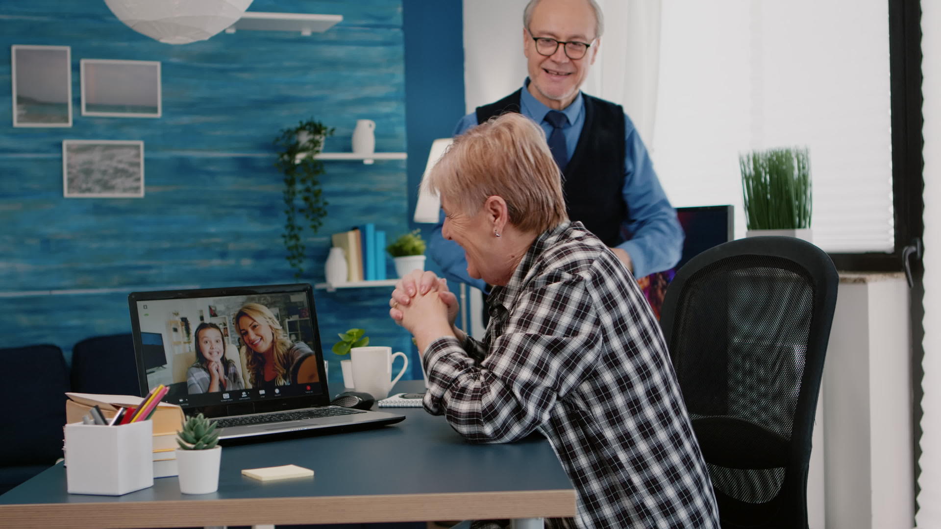 兴奋的妇女及其丈夫在笔记本电脑上举行电视会议视频的预览图