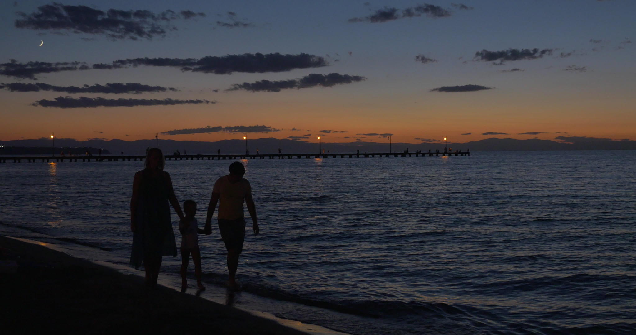 父母和孩子黄昏时在海里行走视频的预览图