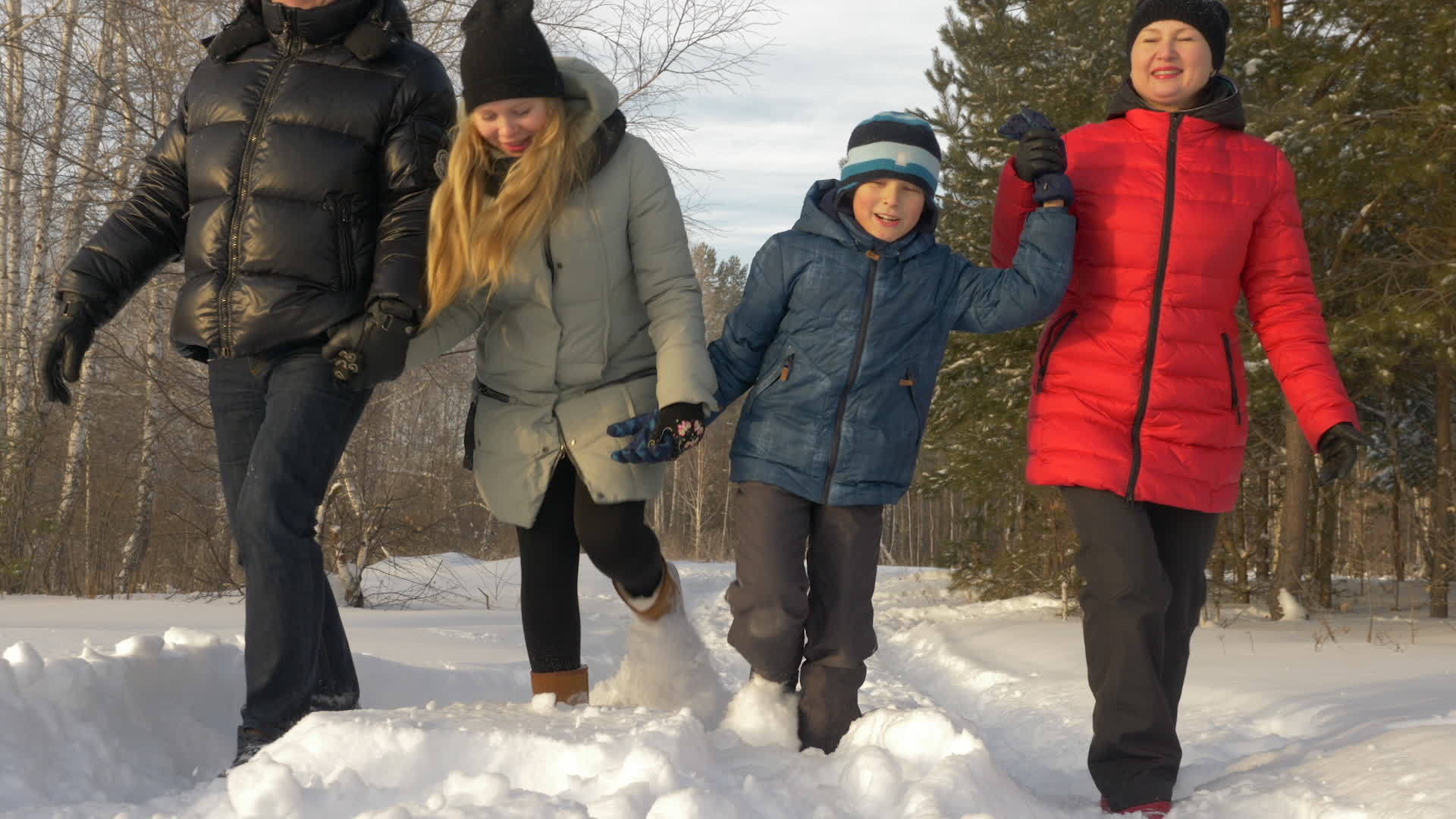 在寒冷的冬天公园里走过雪路的友好家庭阳光明媚视频的预览图