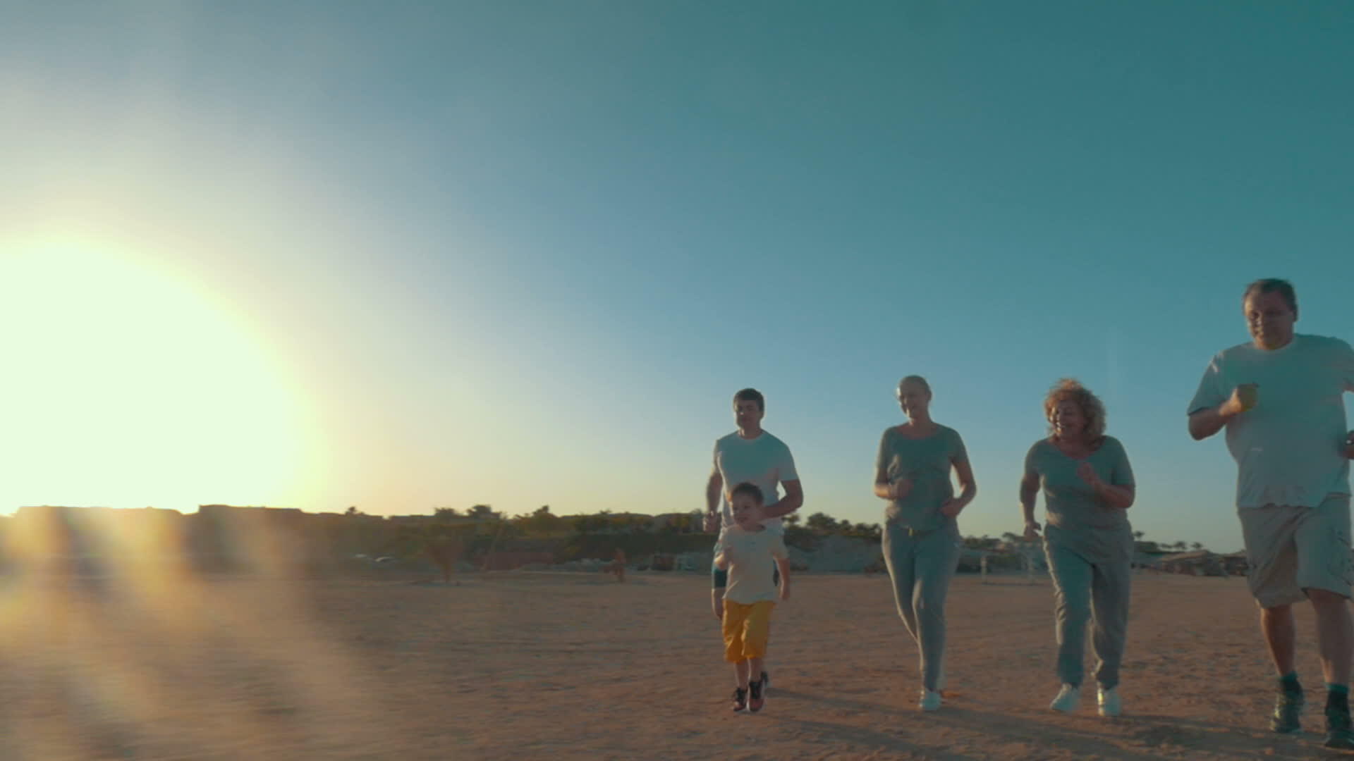 日落时一家人在海滩上奔跑视频的预览图