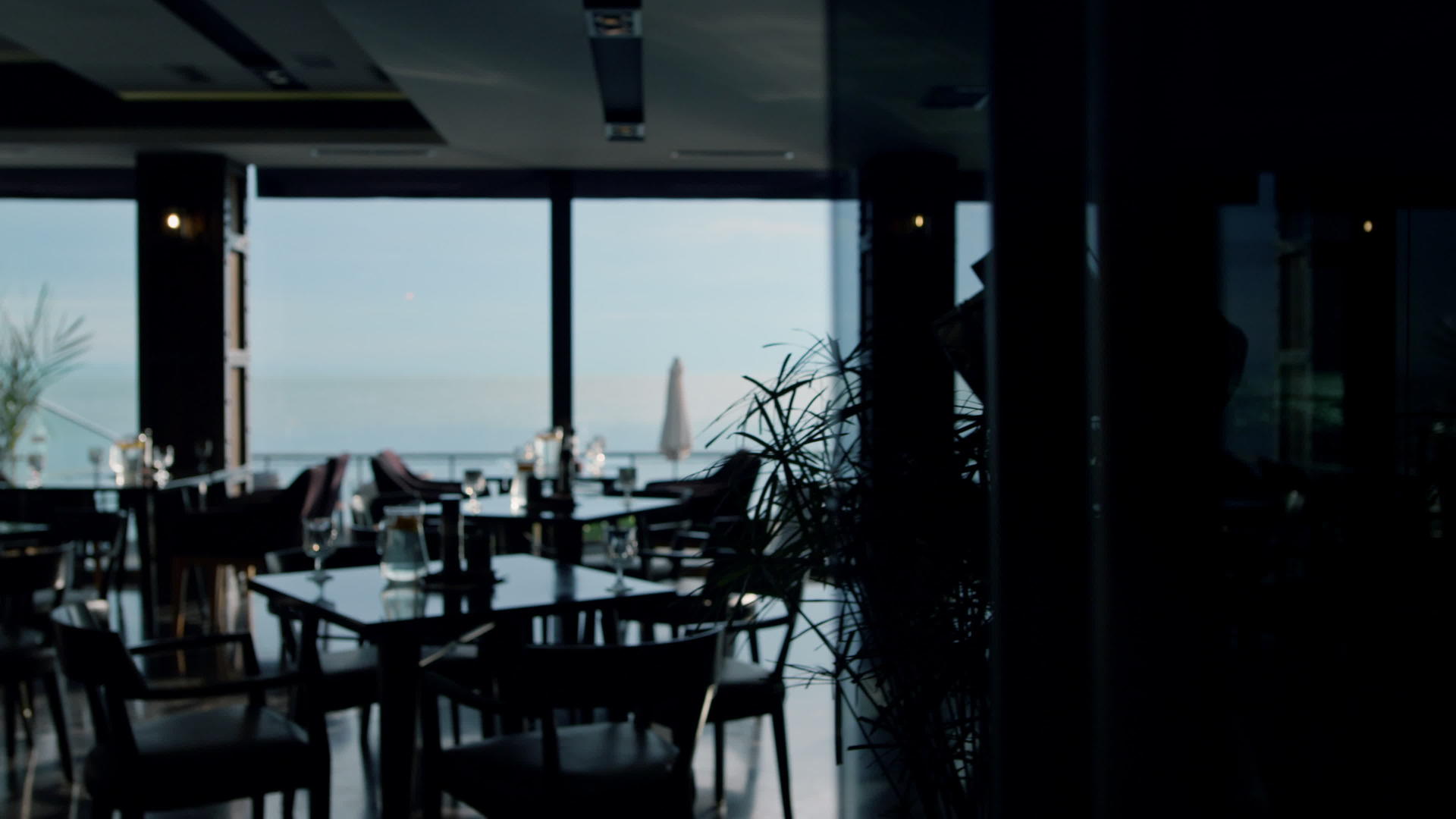 提供午餐桌在宽敞的黑暗自助餐厅内享受美丽的海景视频的预览图