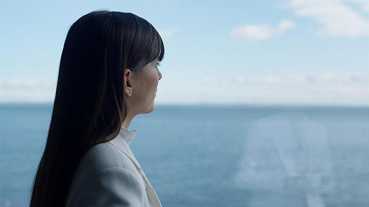 特写女导演思考海洋窗景视频的预览图