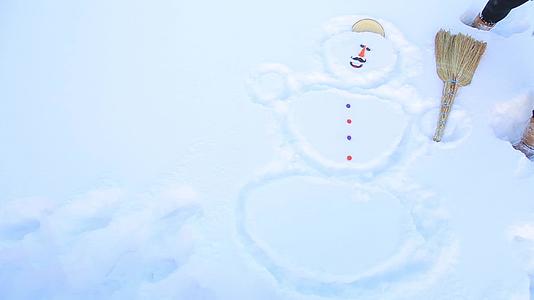 一个女孩在雪中画了一个雪人盖住他的头视频的预览图