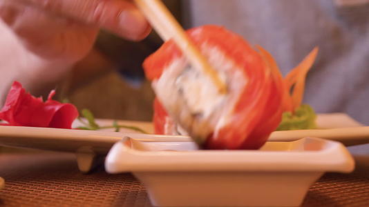 日本餐馆的寿司卷泡在酱油里视频的预览图