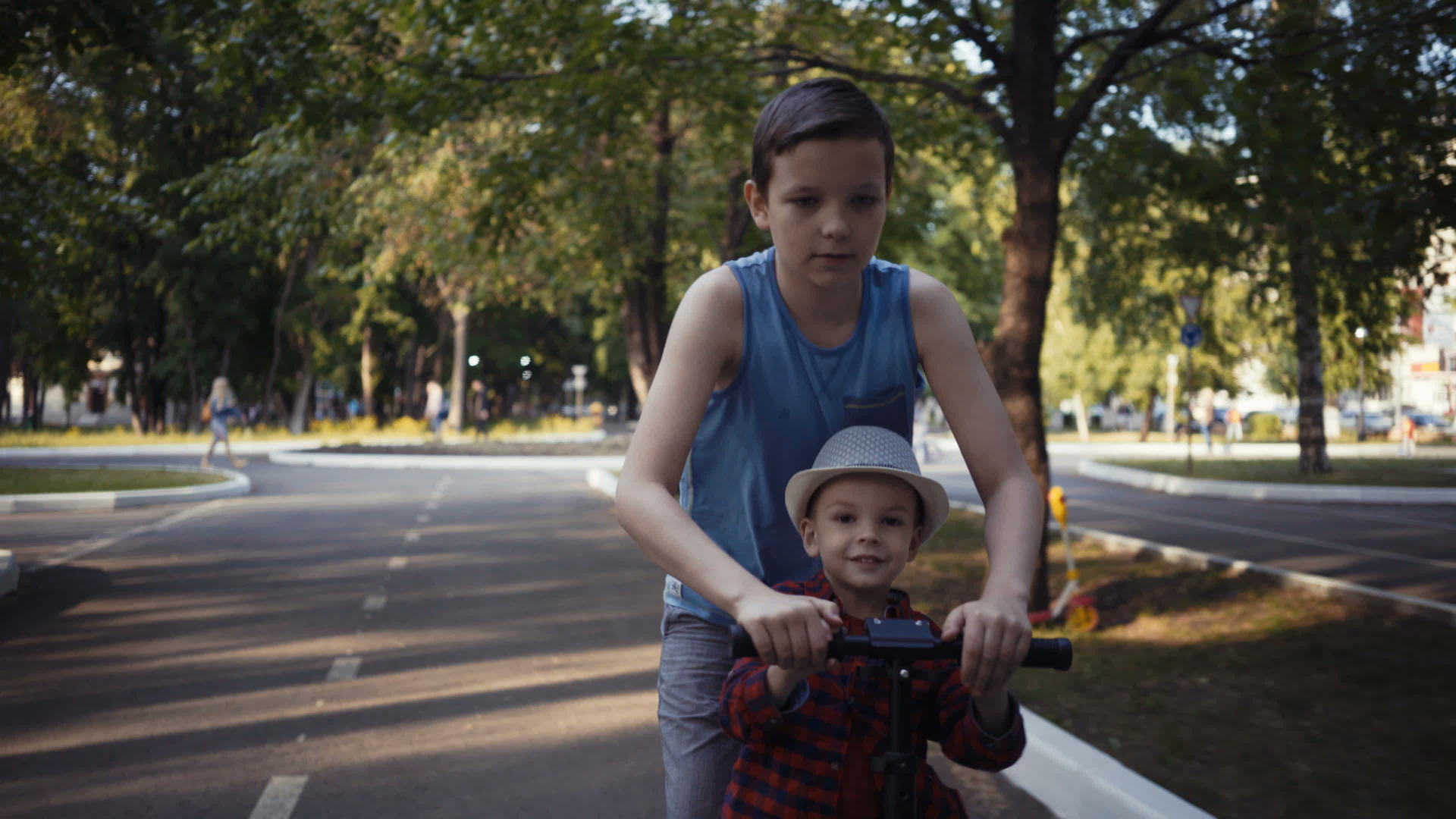 兄弟俩在夏天的公园骑自行车视频的预览图