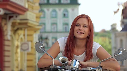 坐在旧街摩托车上的女人视频的预览图