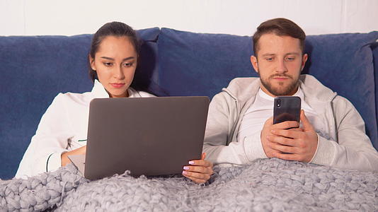 一对夫妇躺在毯子下盯着他们的小东西视频的预览图