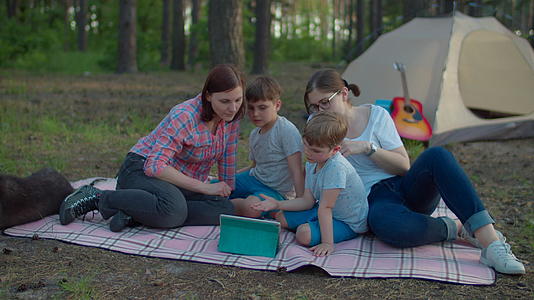 两位30多岁的母亲和两个儿子正在度夏季野营度假和森林帐篷视频的预览图