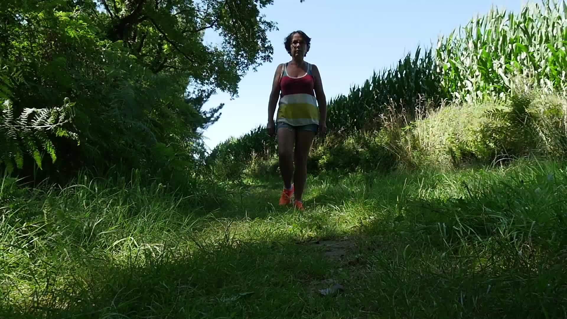夏天中年女性在一条路上慢慢走视频的预览图