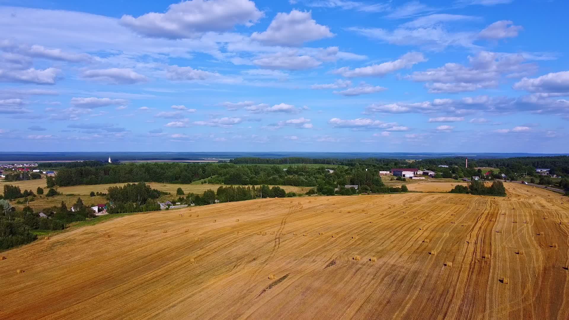 收获小麦后田野上的观光将滚动干草堆的稻草视频的预览图