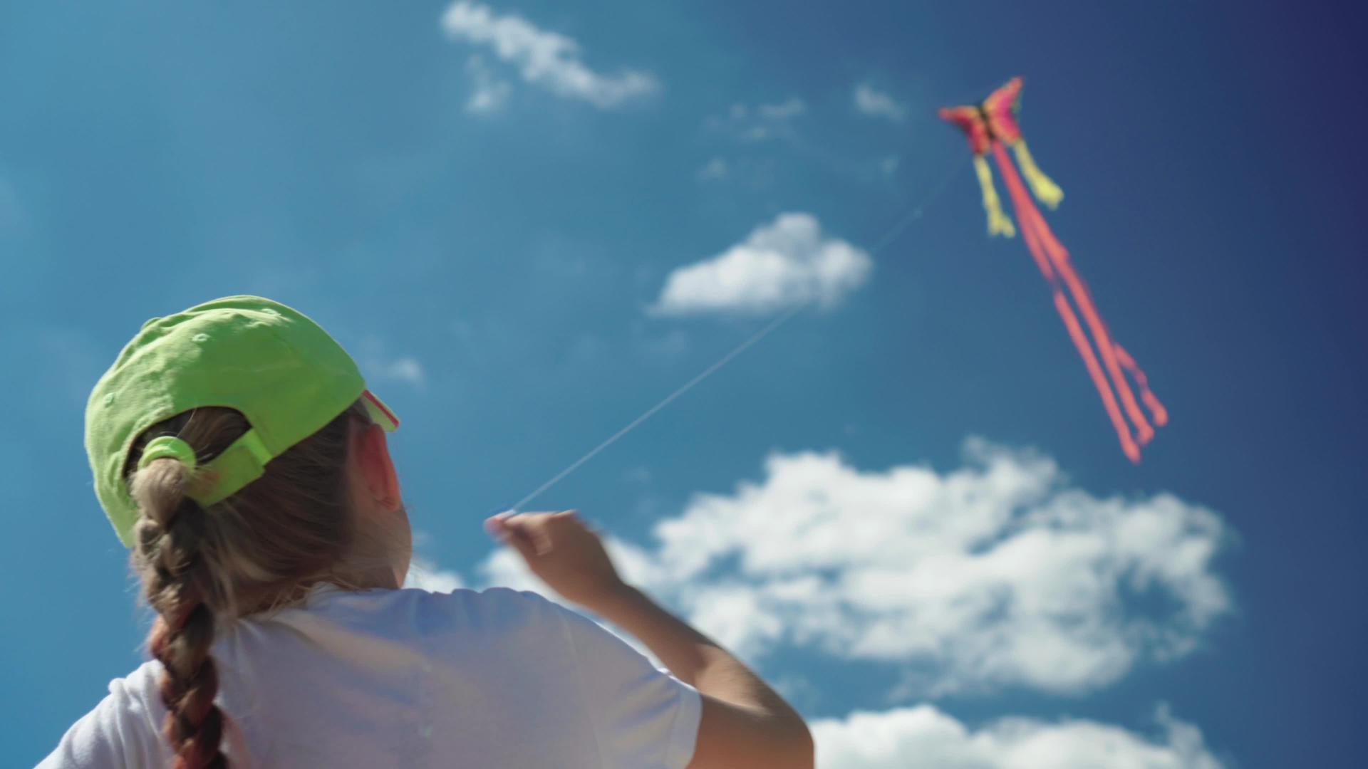 自信的女孩在风中完美的蓝天上玩风筝快乐无忧无虑的孩子视频的预览图