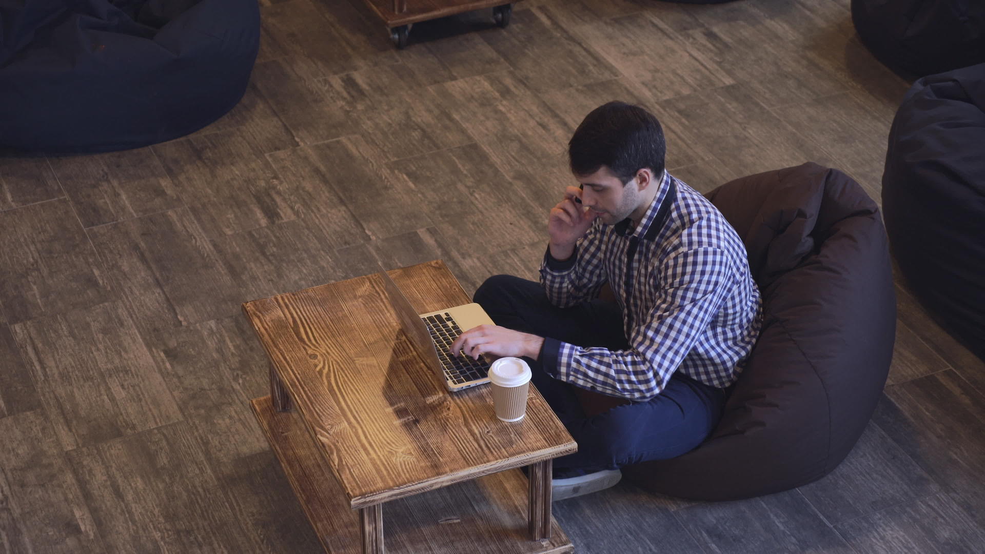 专注于一个人在电话里说话在笔记本电脑上工作视频的预览图