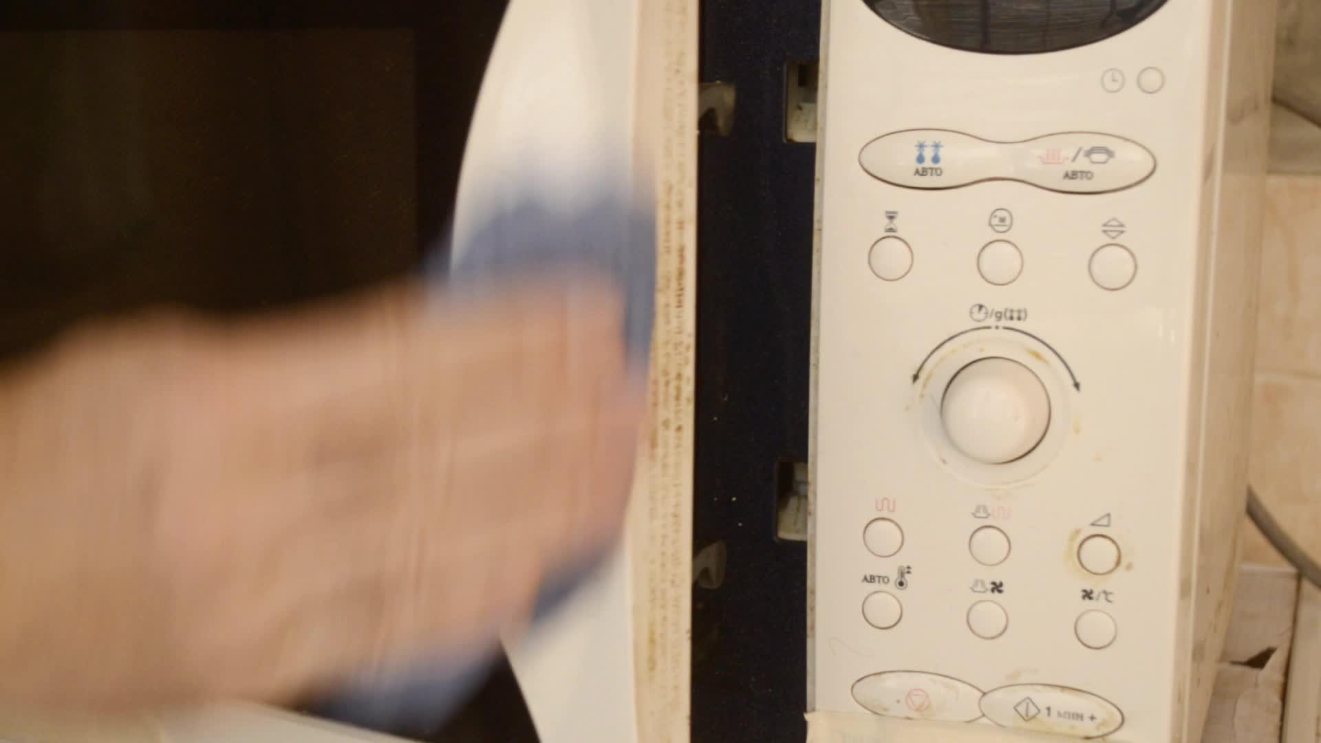 一名男子用湿布擦洗微波炉门的末端清洁肮脏的微波炉视频的预览图