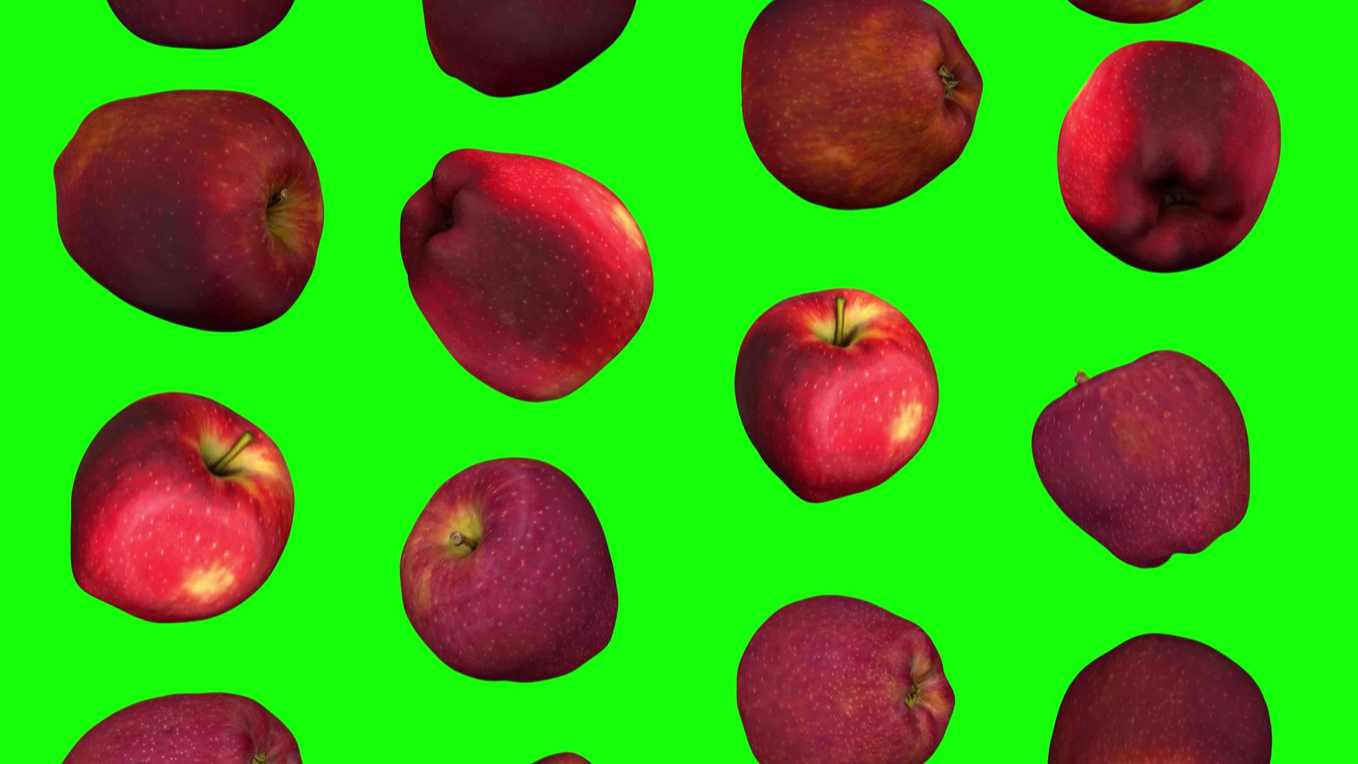 红色美味苹果在绿色背景上翻滚01a视频的预览图
