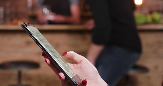酒吧里的年轻女性用她的智能手机滚动文字视频的预览图