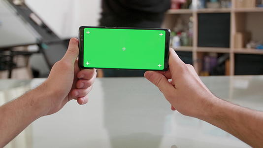 持有绿色屏幕的智能手机保持双向绿屏视频的预览图