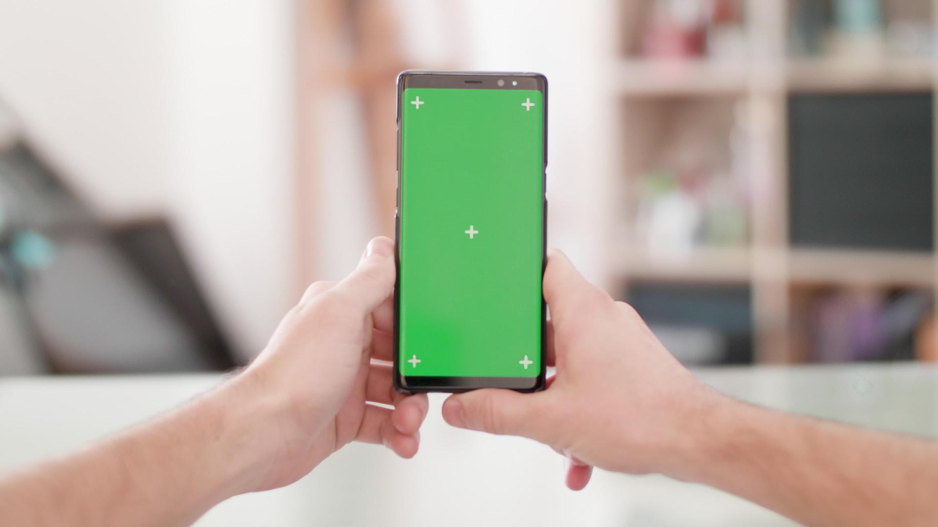 s男人的观点是垂直持有智能手机框架中央有一个绿色屏幕视频的预览图