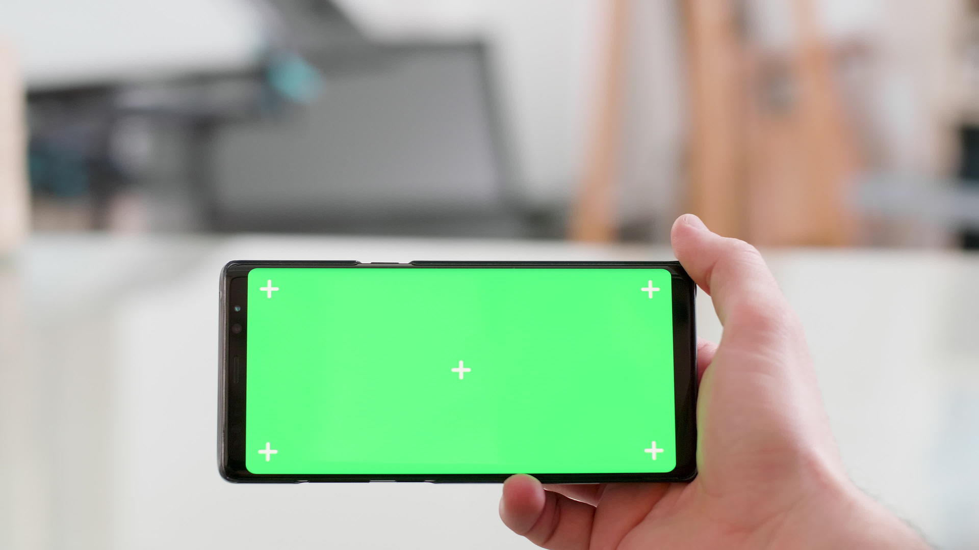 男性水平持有带有绿色屏幕的智能手机视频的预览图