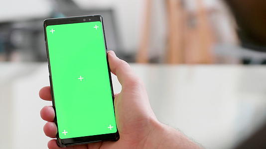 手持绿屏的智能手机近距离拍摄镜头视频的预览图
