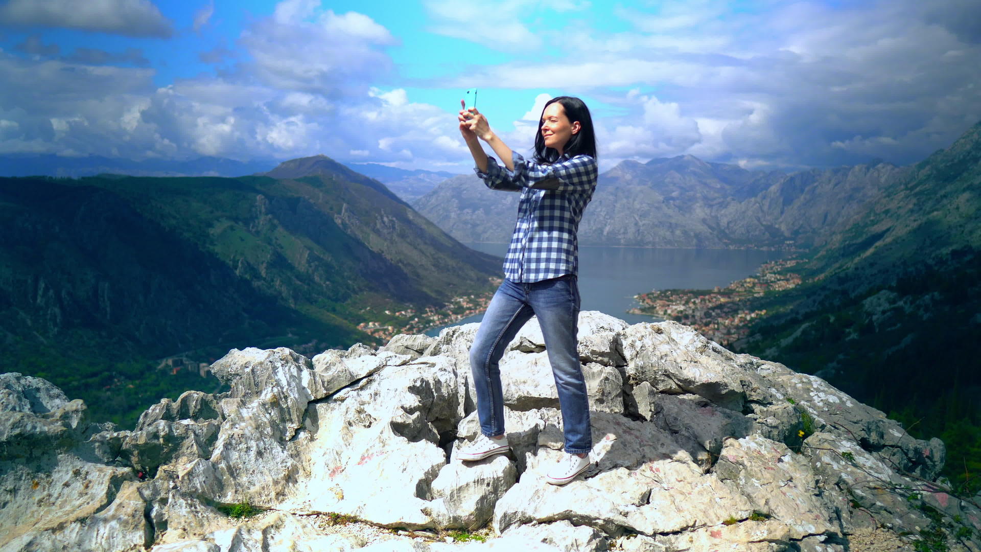 女人站在山顶用智能手机拍照视频的预览图