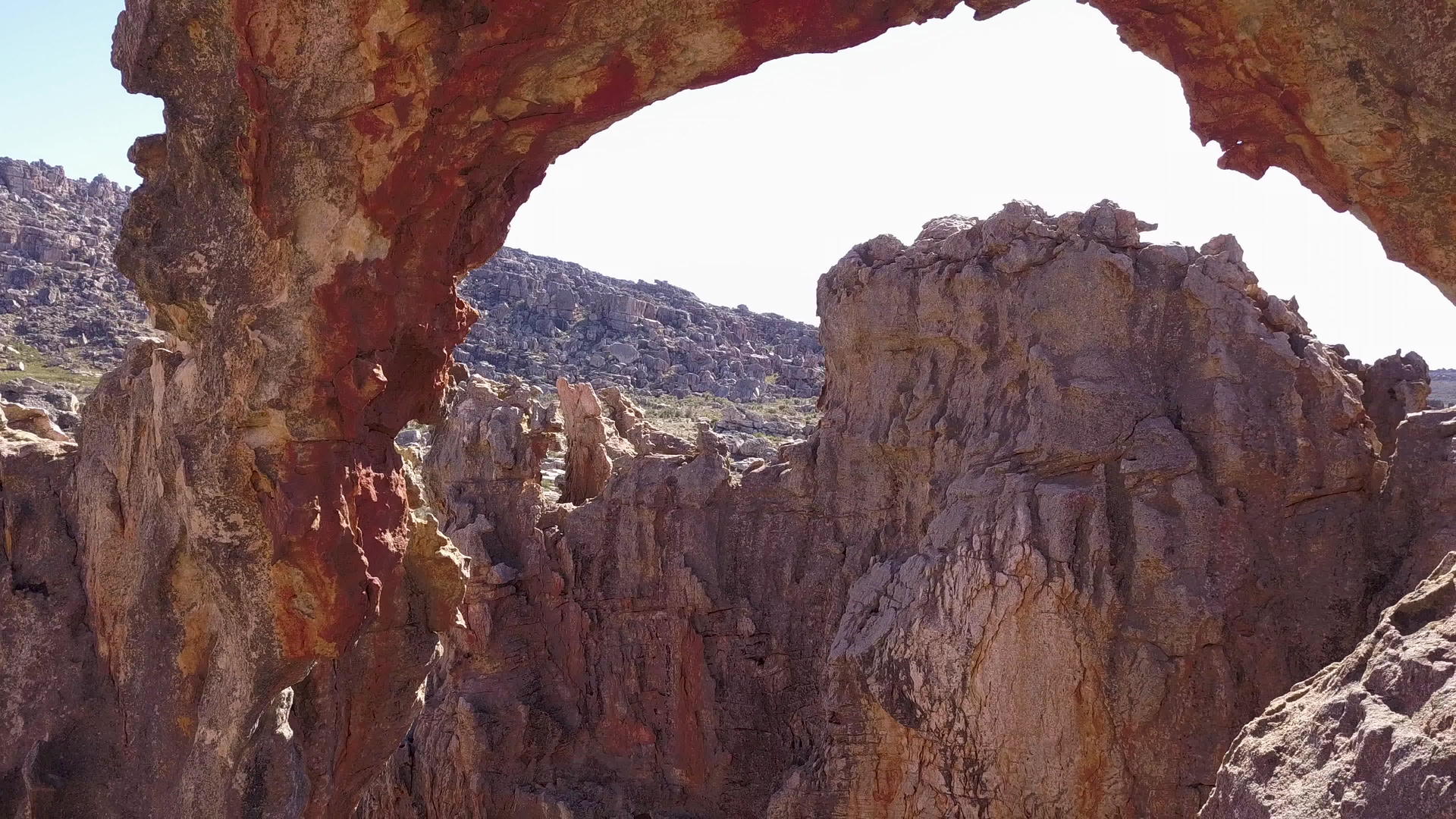 巨大的岩石拱门在山上的空中飞行视频的预览图