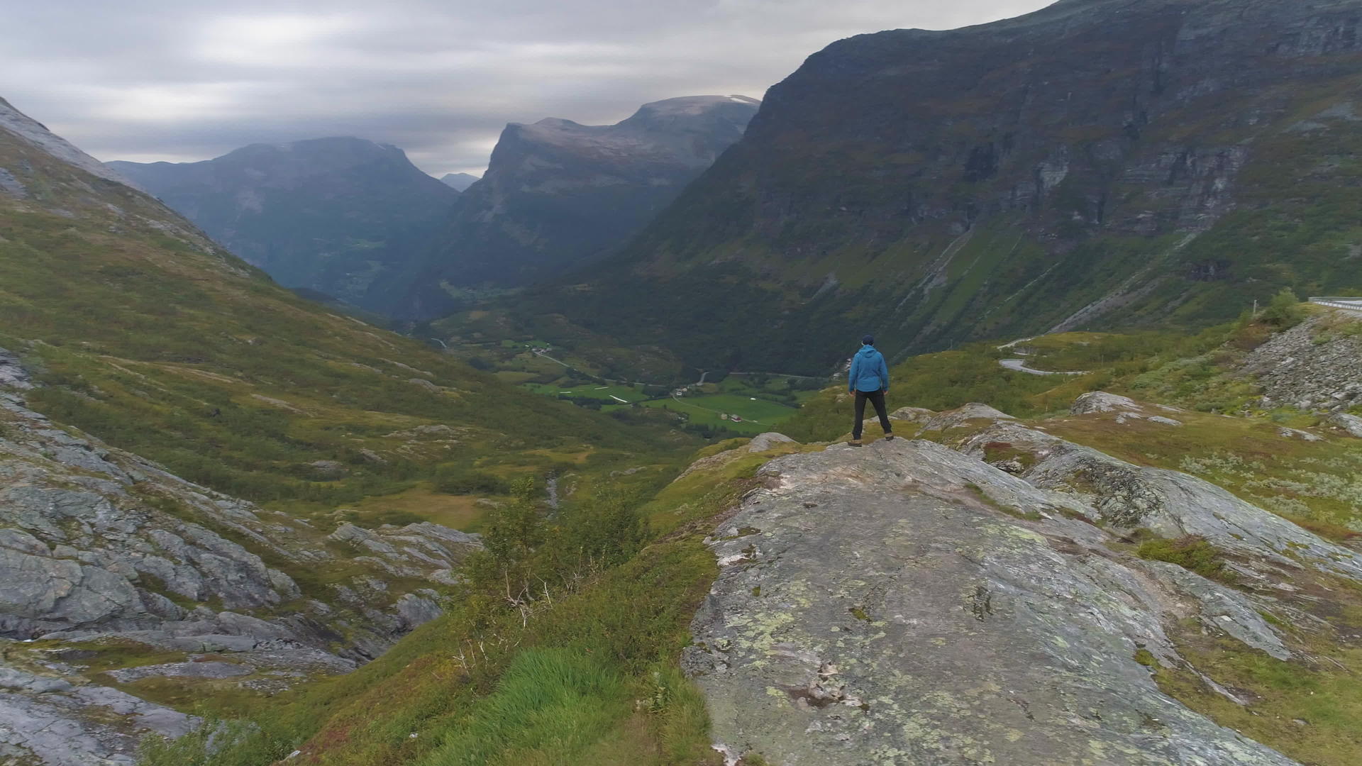 男人在夏天或秋天站在挪威的山谷里鸟瞰无人机视频的预览图