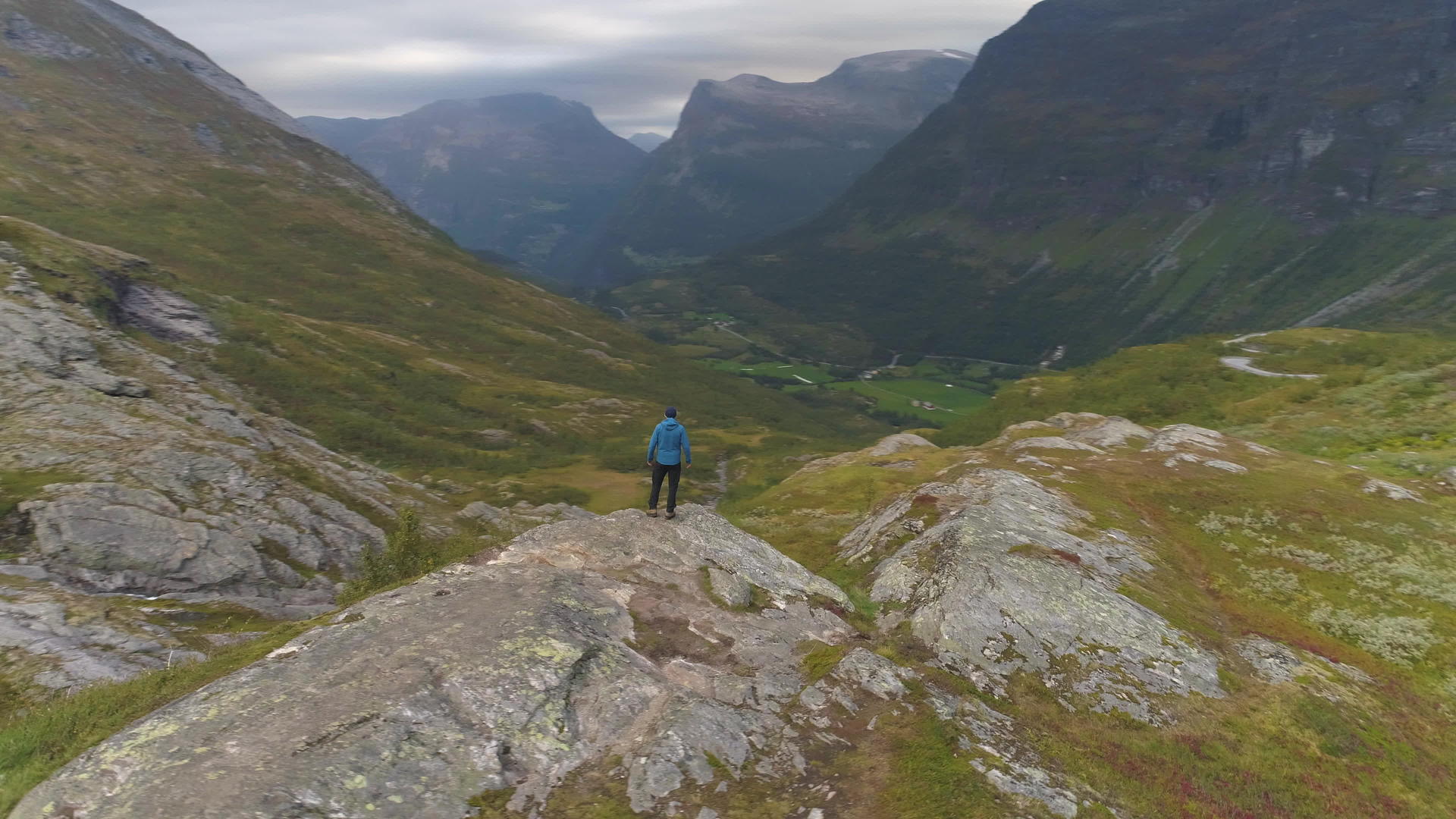 徒步旅行者在夏天或秋天站在挪威山区鸟瞰图无人机视频的预览图