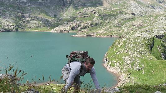 攀登山坡的登山者背景中的湖泊摇篮视频的预览图