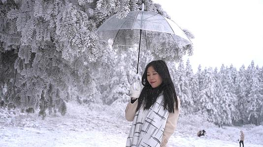 升格美女树下打伞遮下落雪花视频的预览图