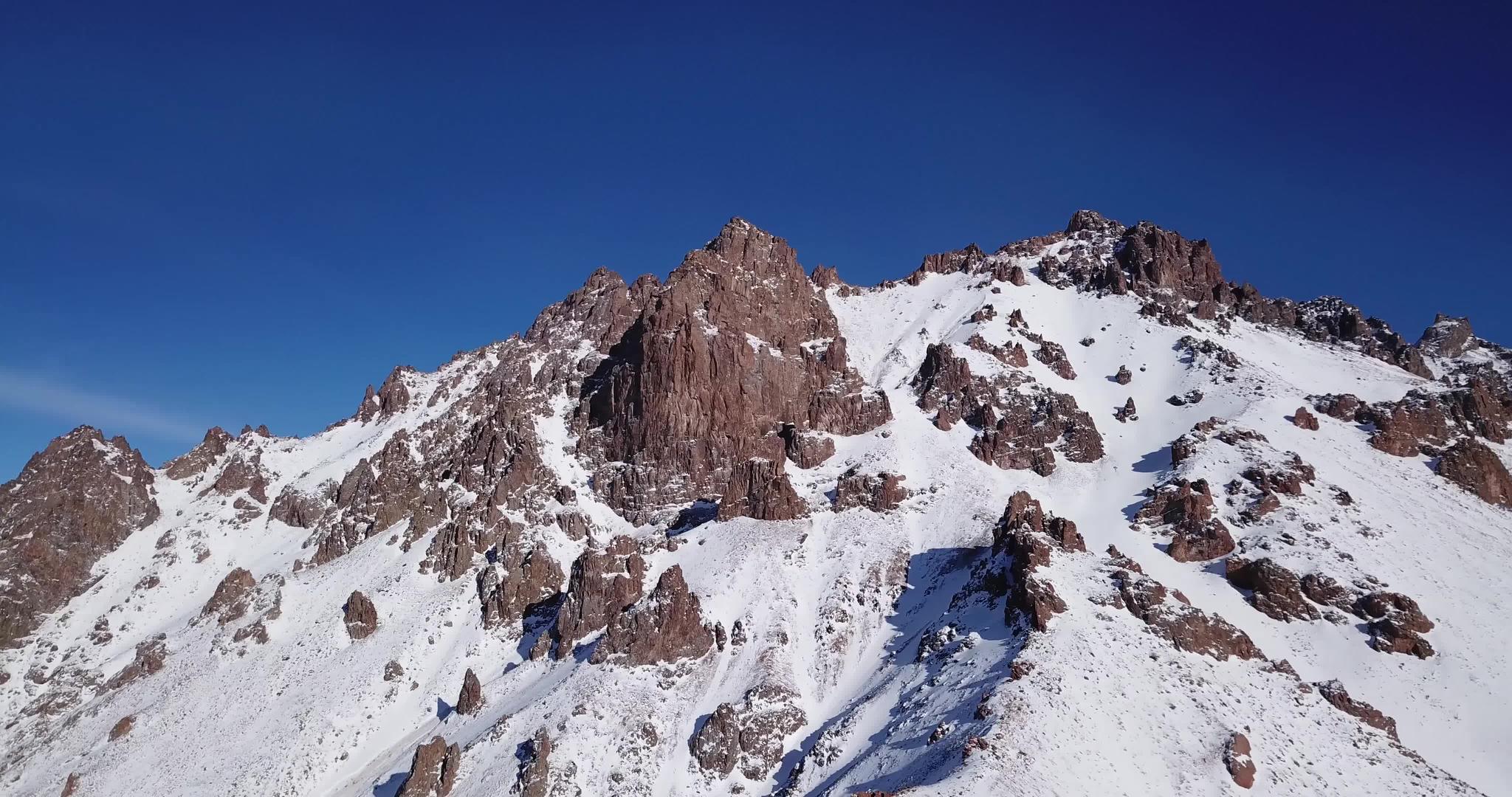 从无人驾驶飞机上可以看到冰雪山峰上的岩石视频的预览图